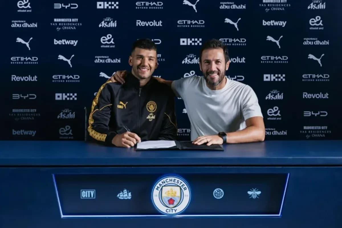 Jugador y entrenador firmando contrato en mesa Jugador y entrenador firmando contrato en mesa