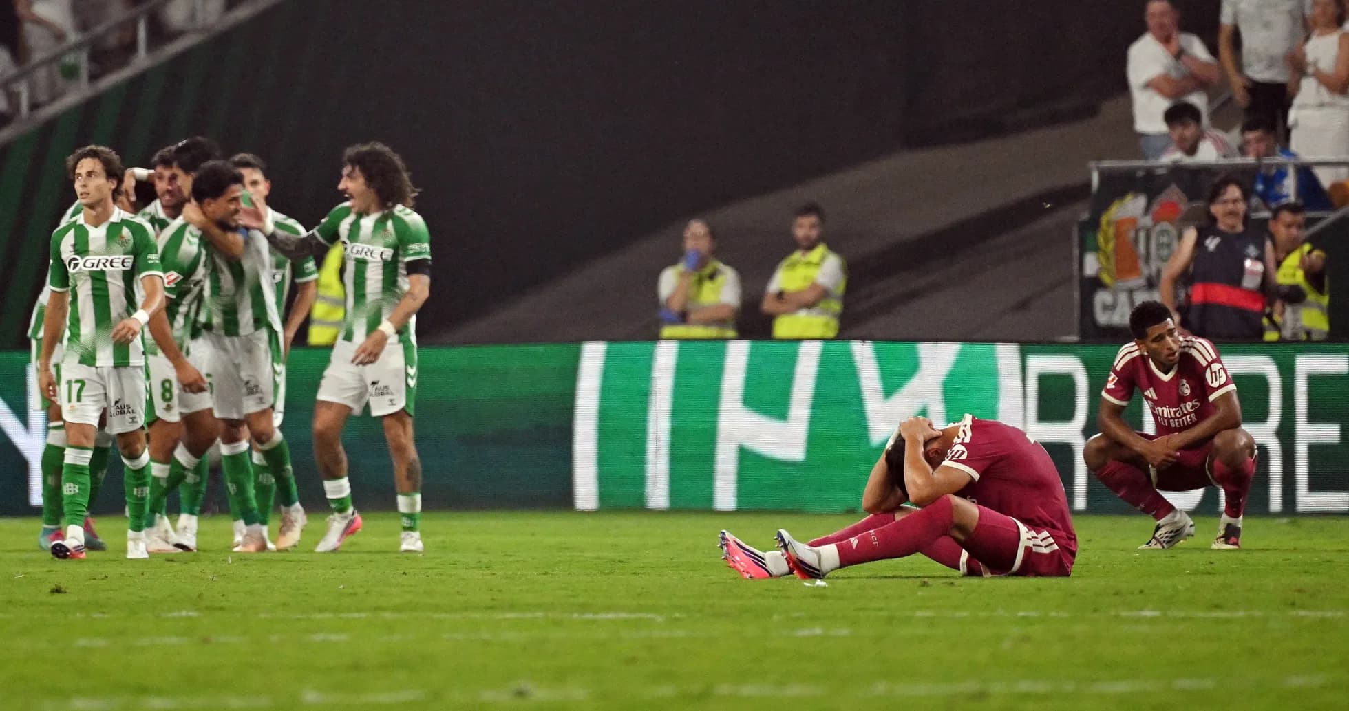 Jugadores de Betis celebrando tras gol, rival caído Jugadores de Betis celebrando tras gol, rival caído