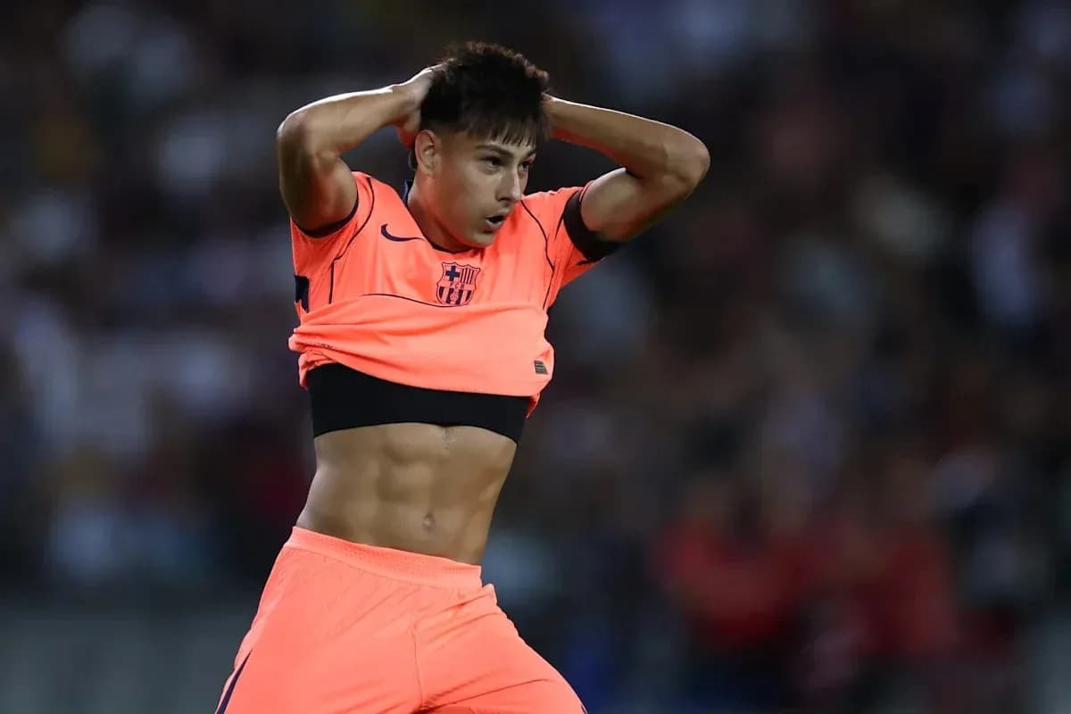 Jugador de fútbol ajustando su camiseta durante partido Jugador de fútbol ajustando su camiseta durante partido