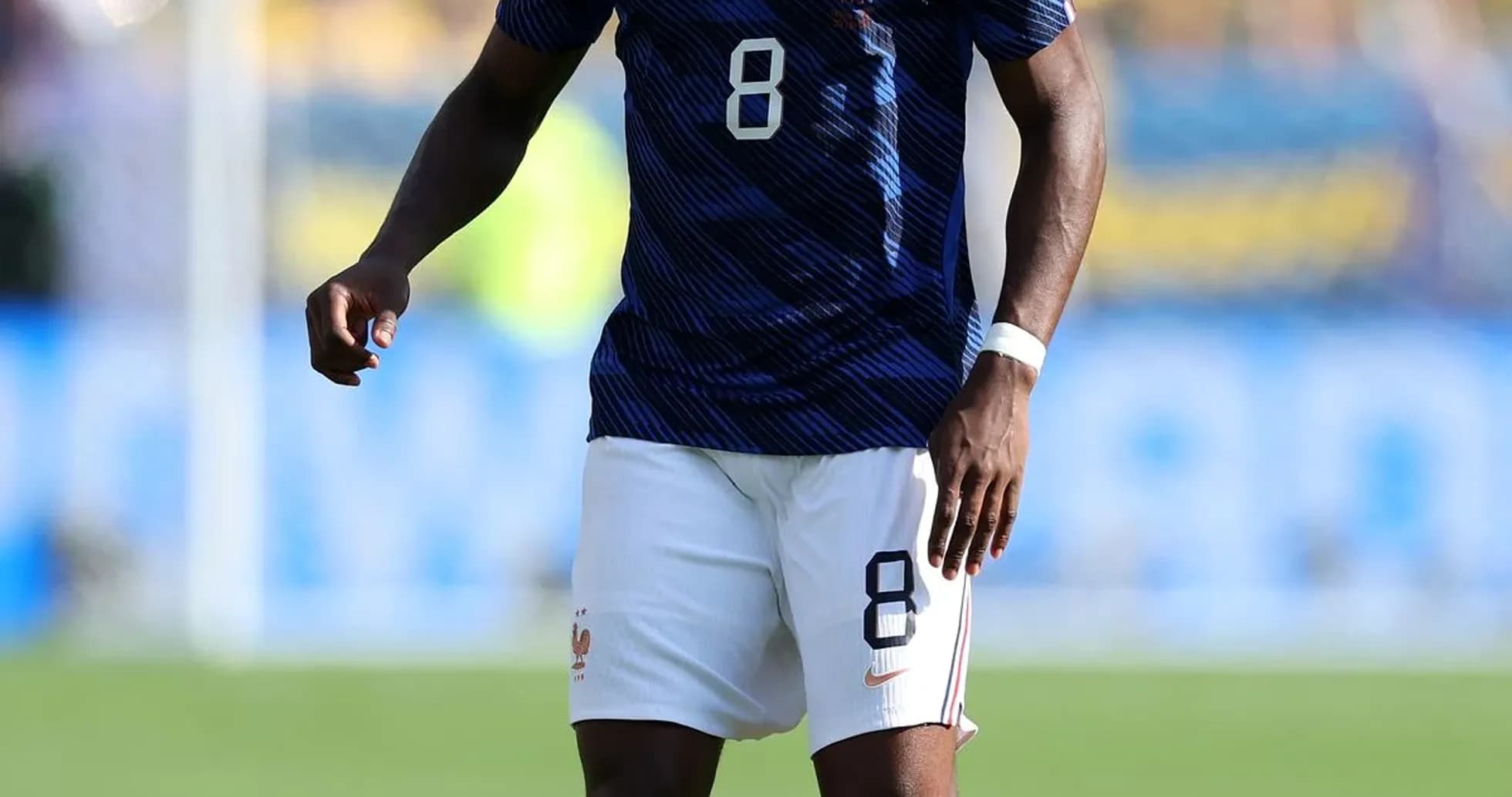Jugador de Francia con balón en campo de fútbol Jugador de Francia con balón en campo de fútbol