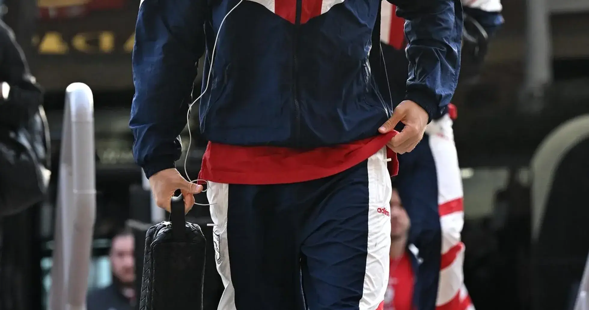 Jugador llegando con atuendo deportivo y maletín Jugador llegando con atuendo deportivo y maletín