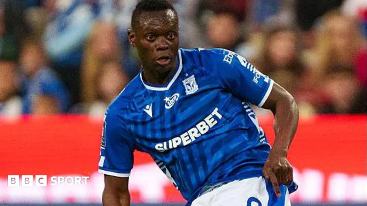 Jugador de fútbol en acción con camiseta azul Jugador de fútbol en acción con camiseta azul