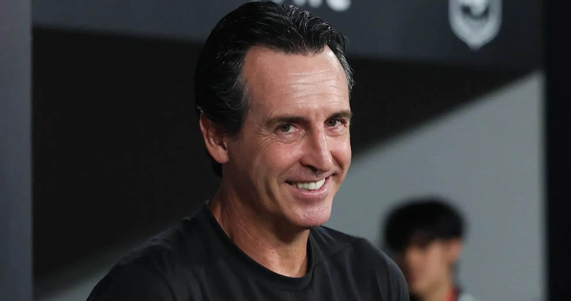 Entrenador sonriendo en el banquillo durante partido Entrenador sonriendo en el banquillo durante partido