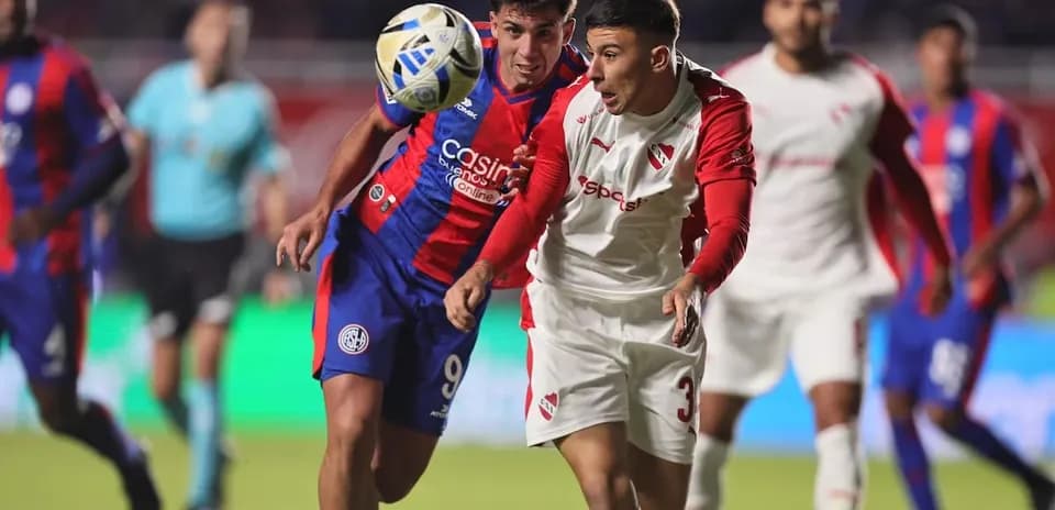Jugadores de Independiente y San Lorenzo compiten por el balón Jugadores de Independiente y San Lorenzo compiten por el balón