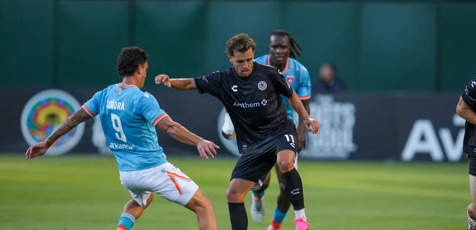 Jugador de Miami FC desafiando a rival de Oakland Roots Jugador de Miami FC desafiando a rival de Oakland Roots