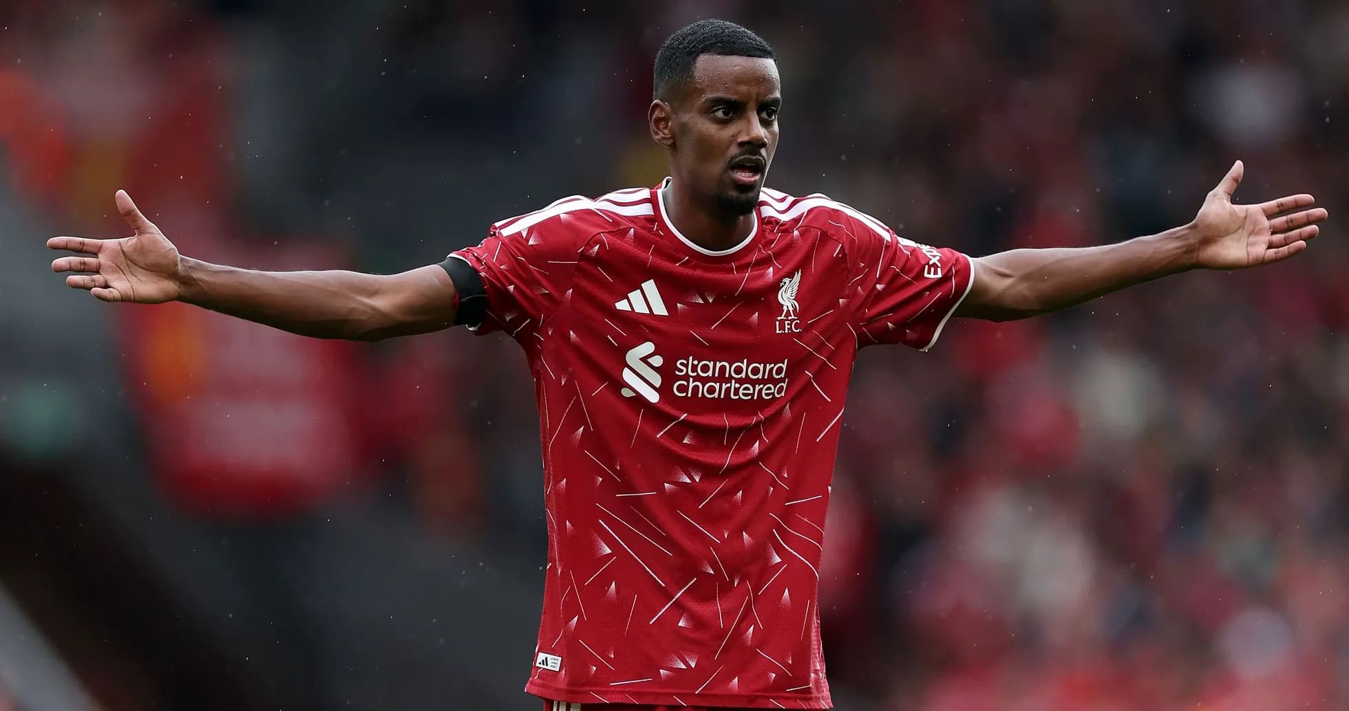 Jugador de Liverpool con brazos extendidos en el campo Jugador de Liverpool con brazos extendidos en el campo