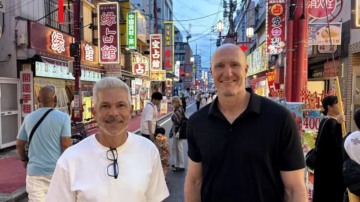 Dos hombres sonriendo en calle iluminada de Tokio Dos hombres sonriendo en calle iluminada de Tokio
