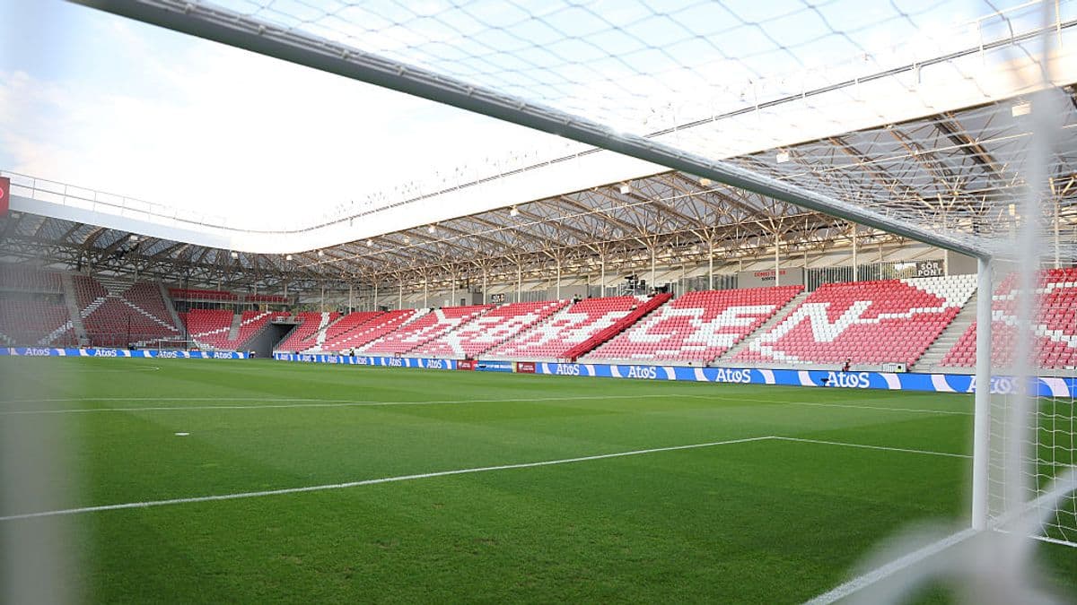 Campo de fútbol con gradas vacías y césped verde Campo de fútbol con gradas vacías y césped verde
