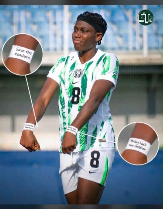 Jugadora con camiseta de Nigeria mostrando mensajes en muñecas Jugadora con camiseta de Nigeria mostrando mensajes en muñecas