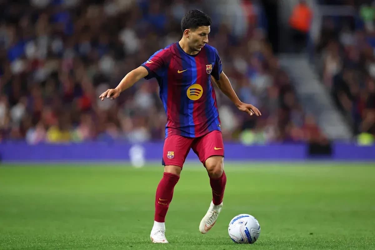 Jugador de Barça controlando el balón en el campo Jugador de Barça controlando el balón en el campo