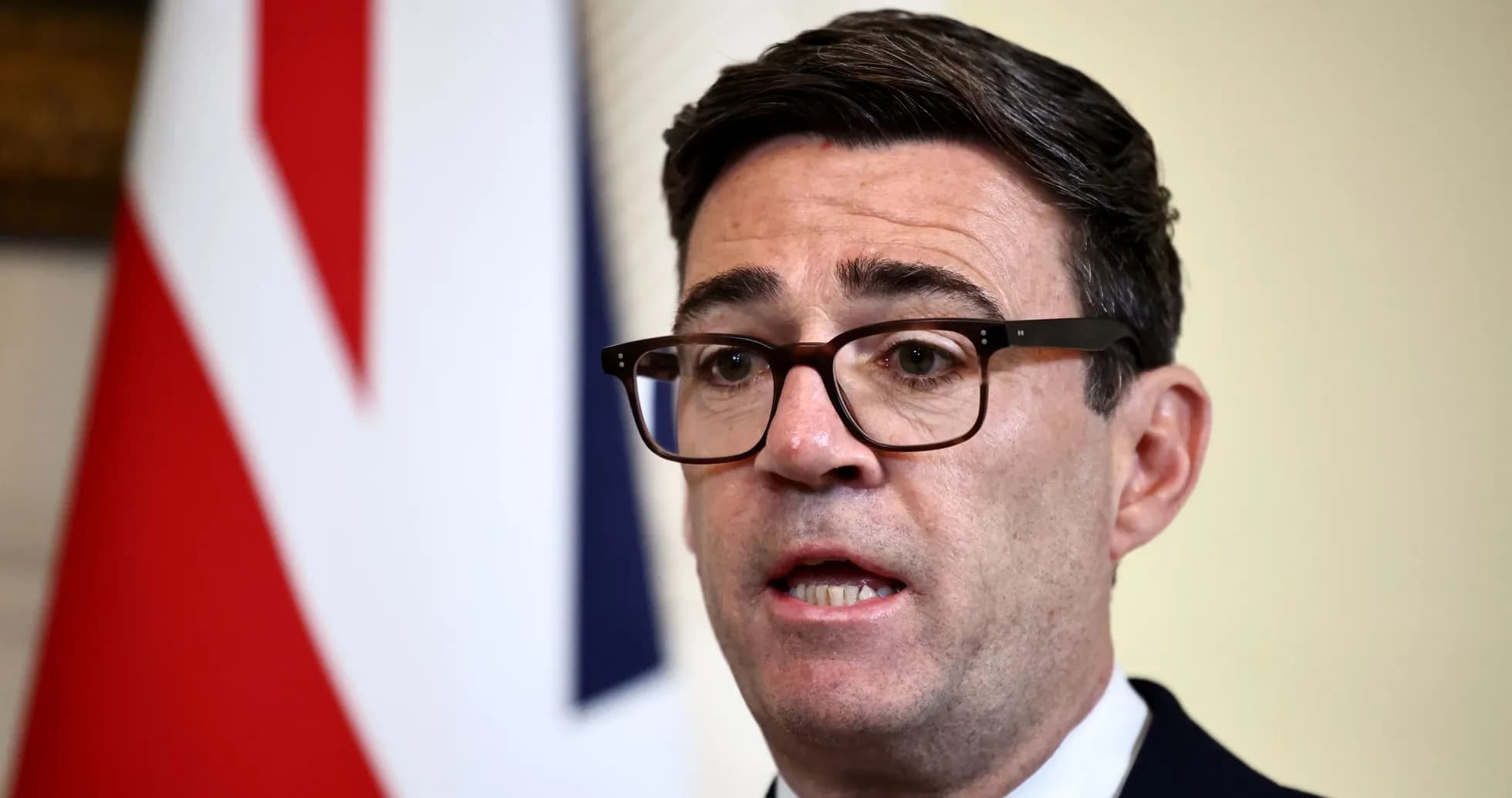 Hombre hablando frente a una bandera británica Hombre hablando frente a una bandera británica