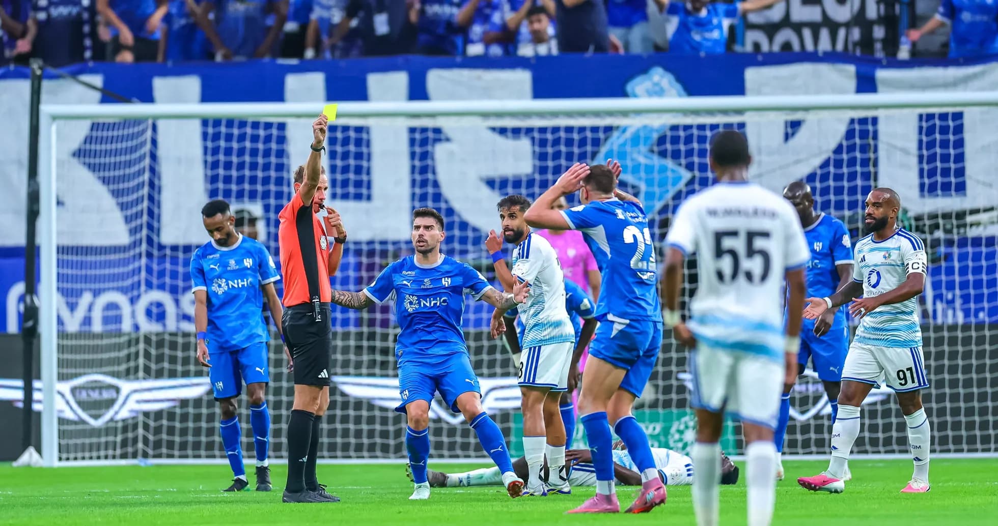Árbitro mostrando tarjeta amarilla a jugador en partido Árbitro mostrando tarjeta amarilla a jugador en partido