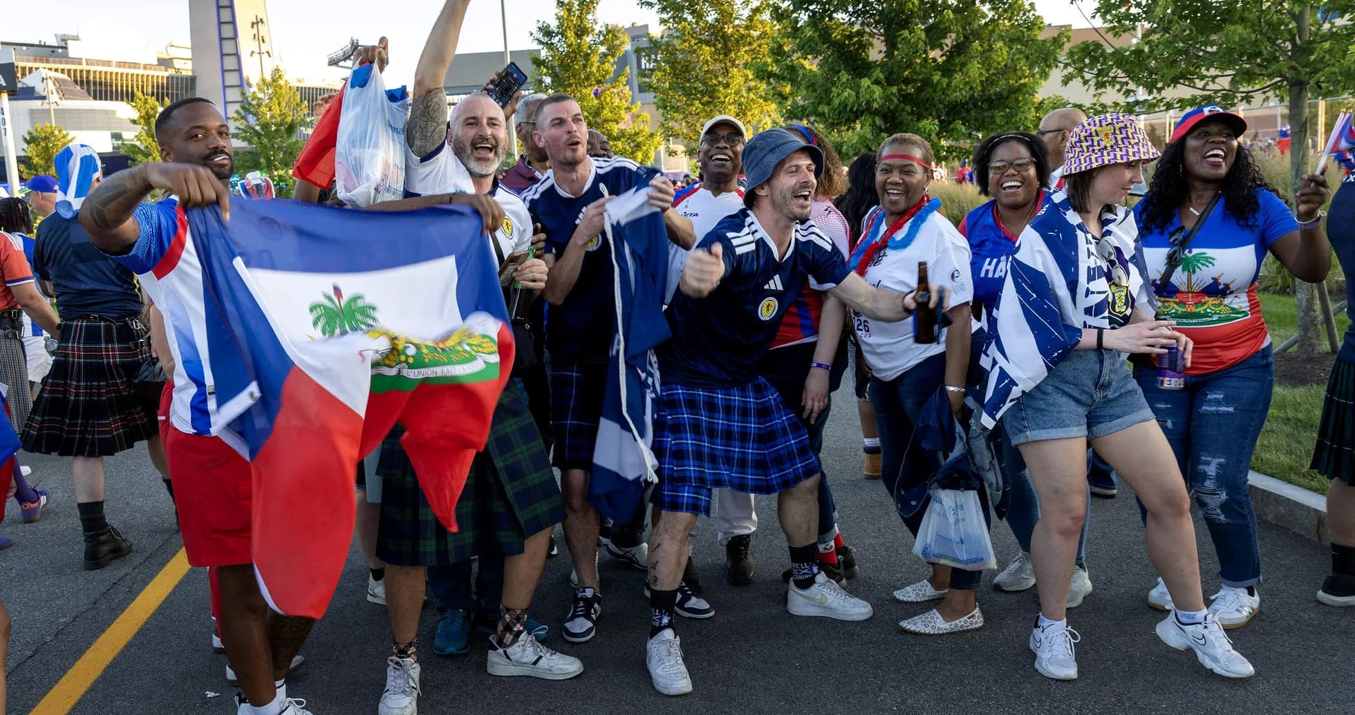Aficionados celebrando con banderas de Haití y Escocia Aficionados celebrando con banderas de Haití y Escocia