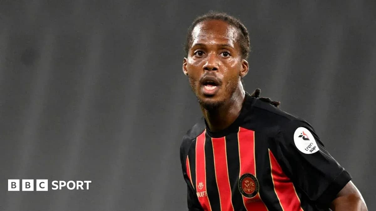 Jugador de fútbol en acción con camiseta roja y negra Jugador de fútbol en acción con camiseta roja y negra